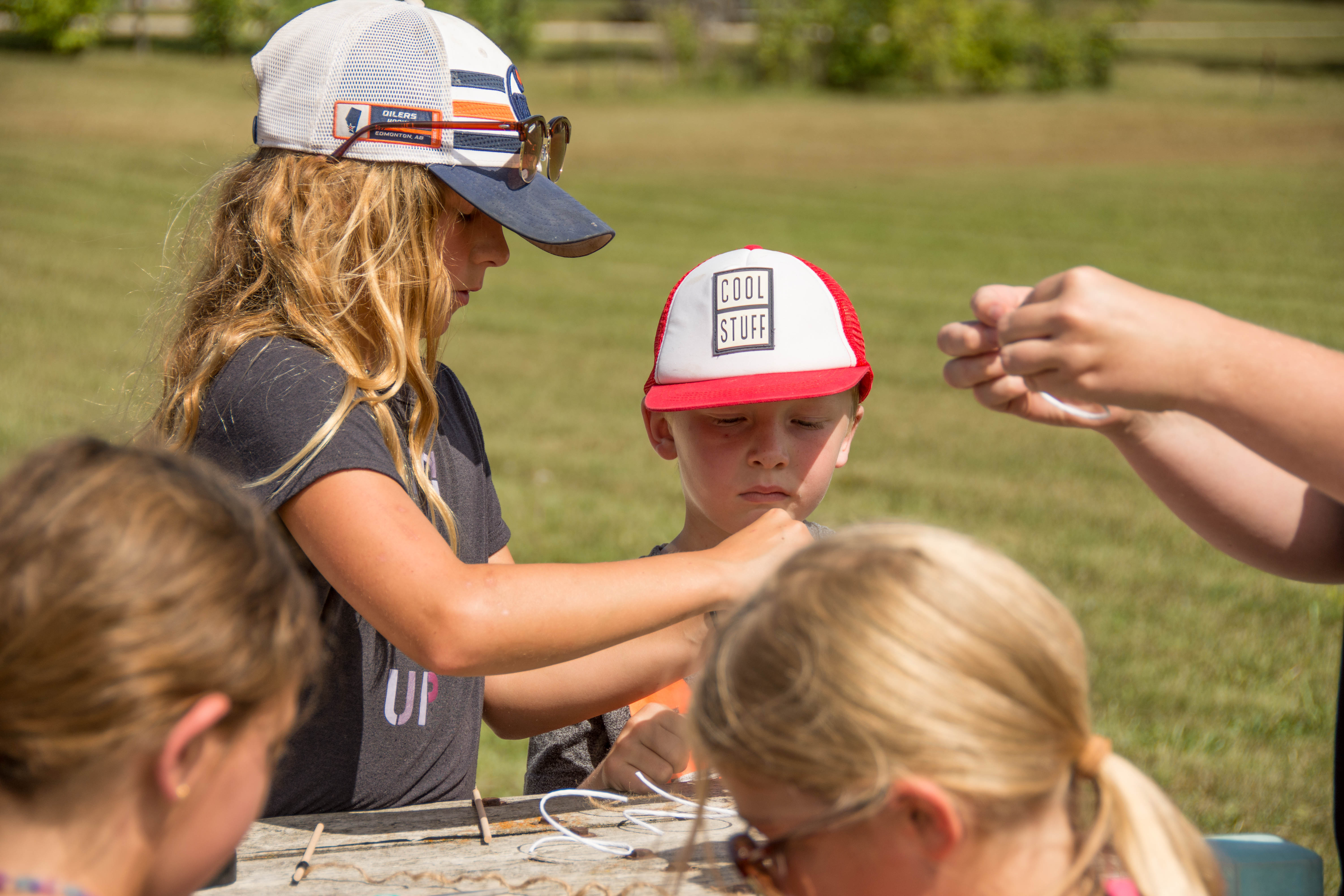 Children outdoors doing crafts at picnic table